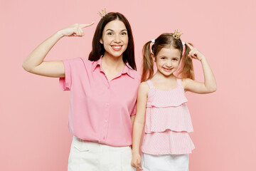 Wall Mural - Happy smiling fun woman wear casual clothes diadem princess crown with child kid girl 6-7 years old. Mother daughter looking camera isolated on plain pastel pink background. Family parent day concept.