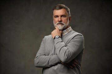 Canvas Print - Portrait of happy casual mature man smiling, senior age man with gray hair, Isolated on dark gray background