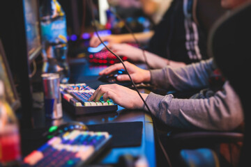 Cyber sport e-sports tournament, team of professional gamers, gamer's hands on mouse and keyboard, pushing button, gamers playing in competitive moba, strategy fps game in a cyber games arena club