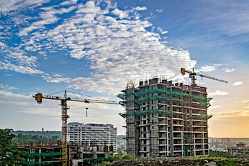 Sunrise and beautiful blue sky behind two tall buildings under construction.