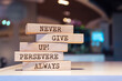 Wooden blocks with words 'Never give up, persevere always'. Inspirational motivational quote