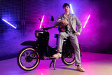 Fototapeta Nowy Jork - 80s sytle young man on scooter with purple background