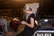 © Austockphoto - Female mechanic checking her transactions on her phone