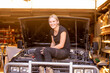 © Austockphoto - confident female mechanic sitting on a 4wd she has been working on in garage repair shop