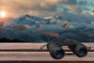 Poster - Binoculars on desk at rock mountain with beautiful nature background.