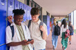 © Monkey Business - Two Male Secondary Or High School Students Outdoors At School Looking At Mobile Phone