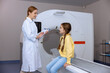 © zinkevych - Medical equipment. Female doctor and little girl patient in MRI room in hospital