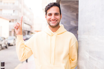 Sticker - young hispanic man feeling like a happy and excited genius after realizing an idea, cheerfully raising finger, eureka!