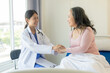 © ArLawKa - Asian elderly woman smiling happily talking and being comforted by a female doctor who speaks to an elderly woman at a desk explaining the results of the examination, examination, treatment