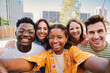 © Jose Calsina - Group of multiracial young student people taking a selfie together looking at camera at the university campus. Close up portrait of happy african american teenager woman laughing with cheerful friends