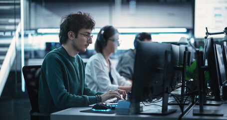 young creative manager using computer, writing a project plan for an innovative technological intern