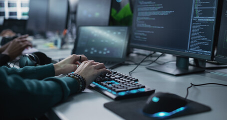 Wall Mural - Close Up of a Software Developer Working on a Desktop Computer, Programming Code Running on Display. Specialist Typing on Keyboard, Coding and Implementing a Technical Feature, Working in an Agency