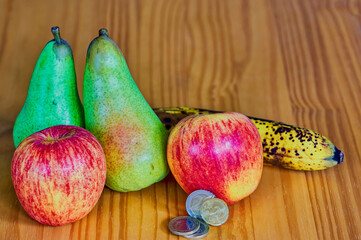 Wall Mural - Fruit lying together with European money on a wooden background.