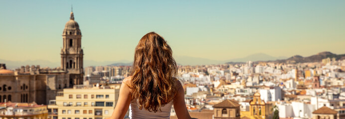 Wall Mural - Woman looking at panoramic view of Malaga city in Spain