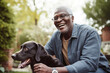 © Trinette Reed - Happy Black senior man laughing with pet dog in backyard. Generative AI.