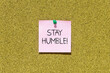 Stay humble text on pink post-it paper pinned on bulletin cork board. This message can be used in business concept about stay humble.