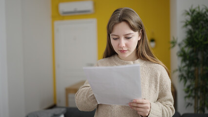 Sticker - Young blonde woman reading document standing at home