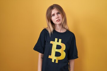 Sticker - Blonde caucasian woman wearing bitcoin t shirt looking sleepy and tired, exhausted for fatigue and hangover, lazy eyes in the morning.