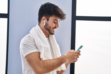 Poster - Young hispanic man smiling confident listening to music at sport center