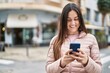 © Krakenimages.com - Young woman smiling confident using smartphone at street
