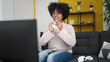 © Krakenimages.com - Young african american woman watching tv sitting on sofa at home