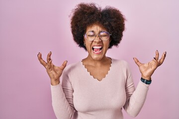 Poster - Young african american woman standing over pink background celebrating mad and crazy for success with arms raised and closed eyes screaming excited. winner concept