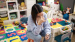 © Krakenimages.com - Young beautiful hispanic woman teacher sitting on table with stressed expression at kindergarten