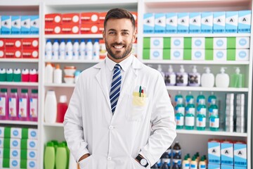 Poster - Young hispanic man pharmacist smiling confident standing at pharmacy