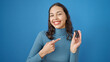 © Krakenimages.com - Young beautiful hispanic woman smiling confident pointing to key of new car over isolated blue background