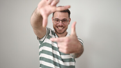 Sticker - Young caucasian man smiling confident doing frame gesture with hands over isolated white background