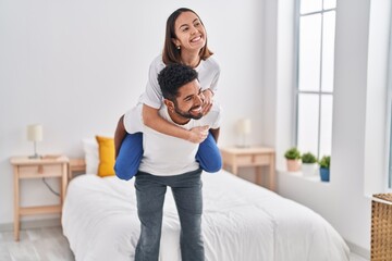 Poster - Man and woman smiling confident holding girlfriend on back at bedroom