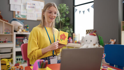 Sticker - Young blonde woman preschool teacher teaching vocabulary lesson on video call at kindergarten