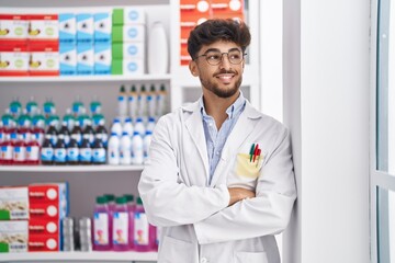 Sticker - Young arab man pharmacist smiling confident standing with arms crossed gesture at pharmacy