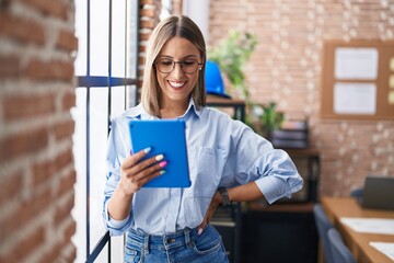 Young beautiful hispanic woman business worker smiling confident using touchpad at office