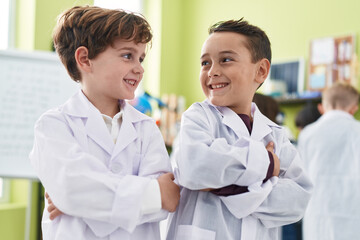 Adorable boys student smiling confident standing with arms crossed gesture at laboratory classroom