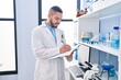 © Krakenimages.com - Young latin man scientist smiling confident writing on notebook at laboratory