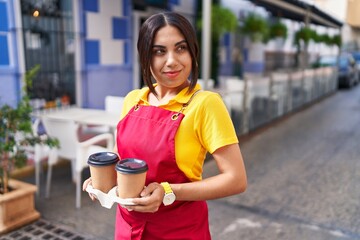 Poster - Young beautiful arab woman waitress smiling confident holding take away coffee at coffee shop terrace