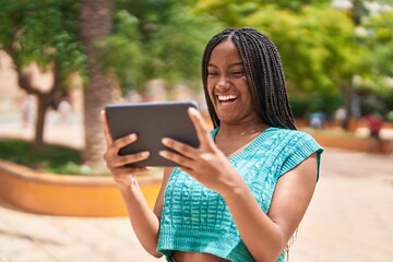 Poster - African american woman smiling confident watching video on touchpad at park