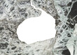 A large hole in a fragged glass window reveals an empty background. The image suggests a sense of damage, mystery, or escape.
