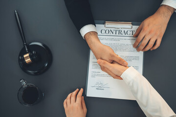 Wall Mural - Top view lawyer or attorneys colleagues handshake after successful legal discussing on contract agreement for lawsuit to advocate resolves dispute in court ensuring trustworthy partner. Equilibrium