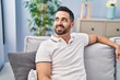 © Krakenimages.com - Young hispanic man smiling confident sitting on sofa at home