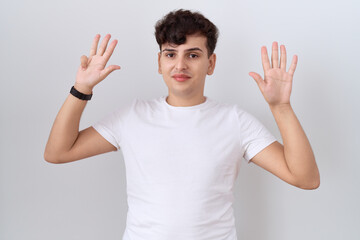 Sticker - Young non binary man wearing casual white t shirt showing and pointing up with fingers number nine while smiling confident and happy.