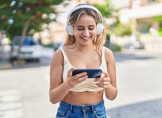 Poster - Young blonde woman smiling confident watching video on smartphone at street