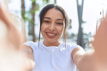 Wall Mural - Young arab woman smiling confident making selfie by camera at street