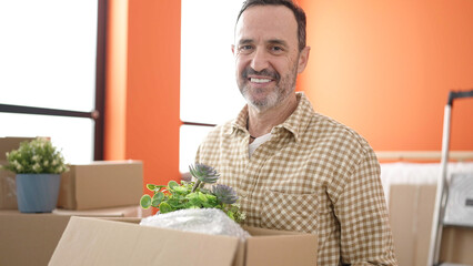 Wall Mural - Middle age man smiling confident holding package at new home