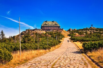 Mountain chalet at the top of Szrenica peak among dwarf mountain pines in the Karkonosze National Park in Poland.