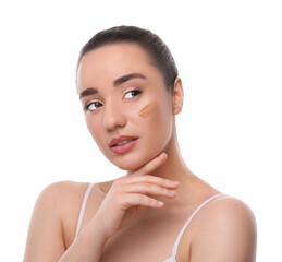 Woman with swatch of foundation on face against white background