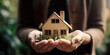 © Gabriela - Hands holding model home, vacation concept. IA generativa