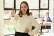 © megaflopp - Cheerful young woman in formal outfit shows thumb up smiling