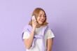 © Pixel-Shot - Young woman in eyeglasses talking by mobile phone on lilac background